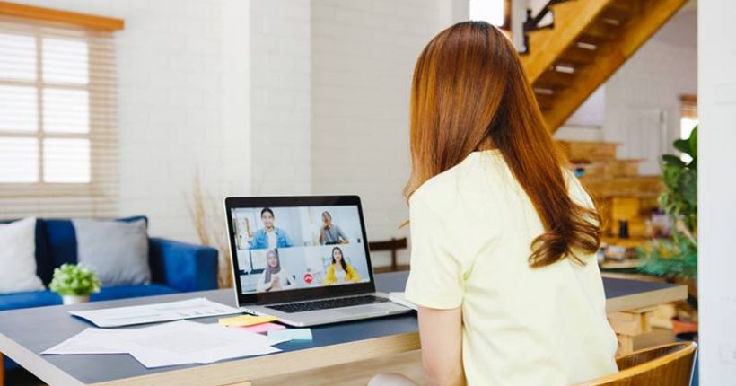 Asia businesswoman using laptop talk to colleagues about plan in video call meeting while working from home at living room. Self-isolation, social distancing, quarantine for corona virus prevention.